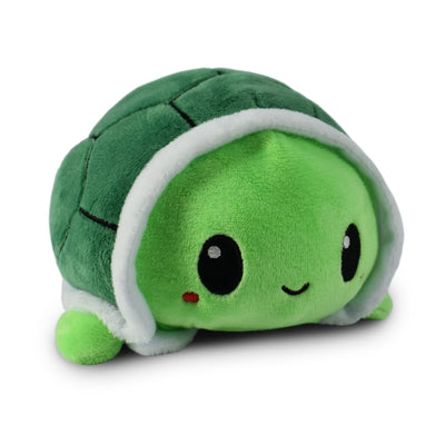 Green plush toy with a smiling face on a white background
