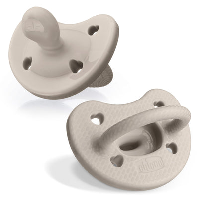 Two beige pacifiers on a white background
