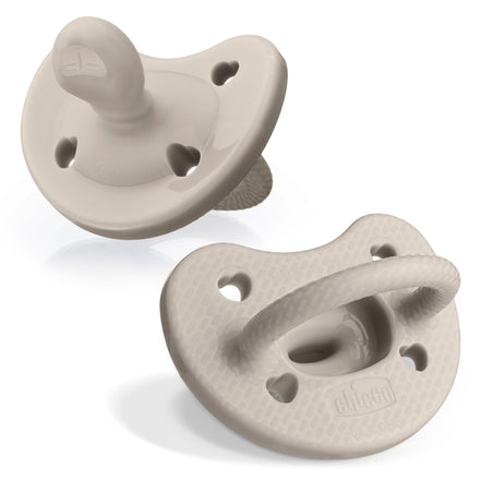 Two beige pacifiers on a white background