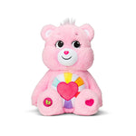 Pink plush toy with a heart on a white background