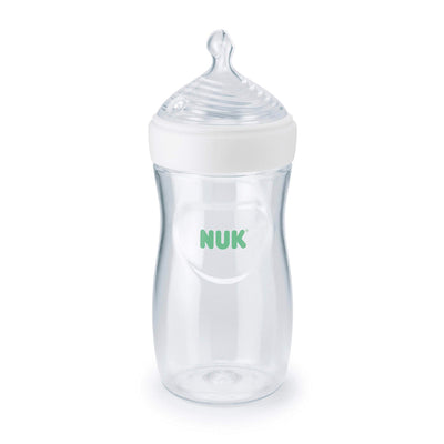 Clear baby bottle with white cap and green 'NUK' logo on a white background
