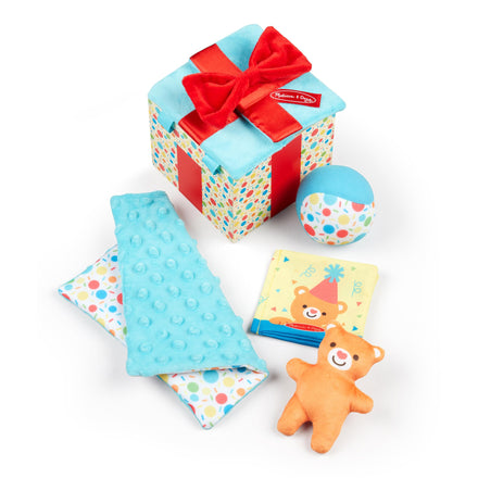 Collection of baby toys and a gift box with a red bow on a white background