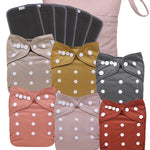 Set of baby cloth diapers with polka dot patterns and bows in various colors.