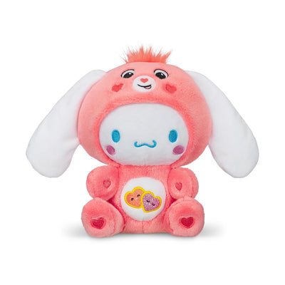 Pink plush toy with white face and heart patterns on a white background