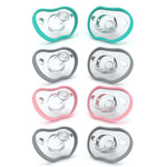 Set of eight baby pacifiers in different colors on a white background