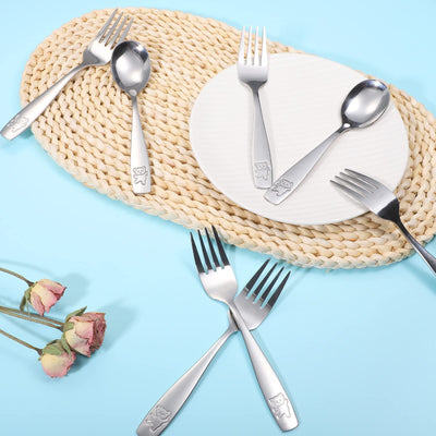 Stainless steel cutlery set on a woven placemat with a light blue background