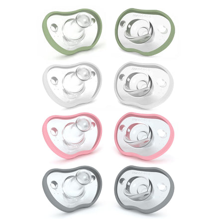 Set of eight baby pacifiers in green, white, and pink on a white background