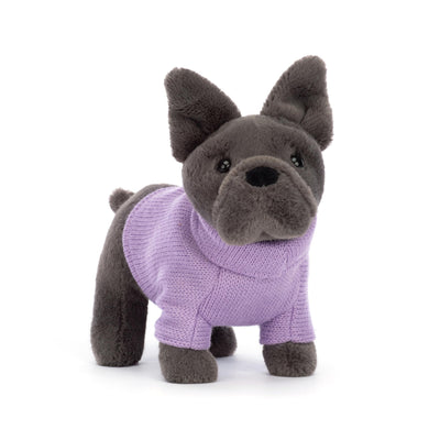 Stuffed dog toy wearing a purple sweater on a white background