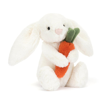White plush bunny holding a carrot on a white background