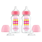 Two Dr. Brown's baby bottles with pink caps and heart patterns on a white background