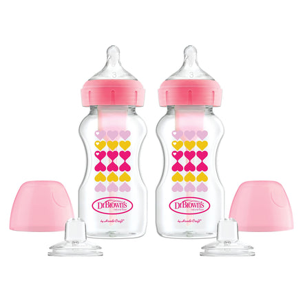 Two Dr. Brown's baby bottles with pink caps and heart patterns on a white background