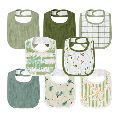 Collection of green and white patterned baby bibs on a white background
