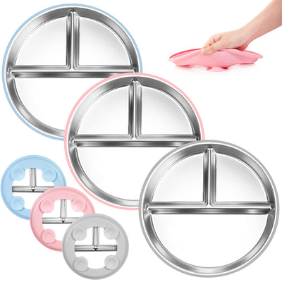 Set of three stainless steel toddler plates with silicone suction in grey, mint green, and pink colors, displayed with a hand holding a pink plate.