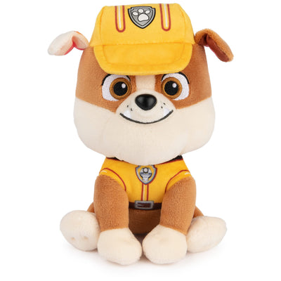 Plush toy dog in a yellow uniform and cap on a white background