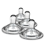 Set of four clear baby bottle nipples on a white background