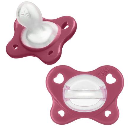 Two pink baby pacifiers on a white background