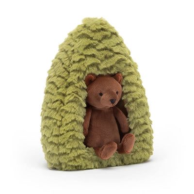 Plush bear inside a green plush treehouse on a white background