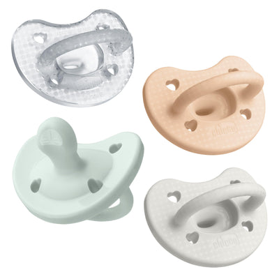 Set of four baby pacifiers in different colors on a white background