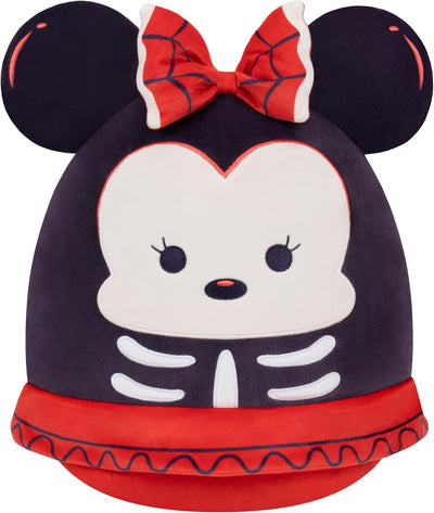 Plush toy with skeleton design and red bow on a black background