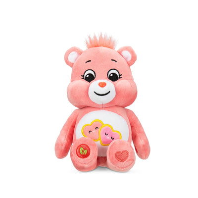 Pink plush bear toy with heart designs on a white background