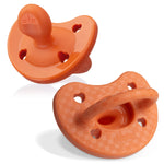 Two orange baby pacifiers on a white background