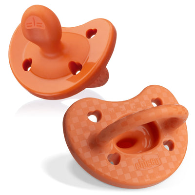 Two orange baby pacifiers on a white background