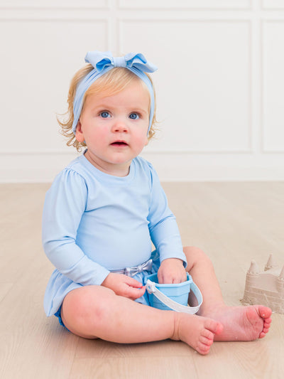 RuffleButts Baby Girls UPF50+ Princess Long Sleeve Bow Skirted One Piece Swimsuit - Crystal Blue Princess, 12-18m