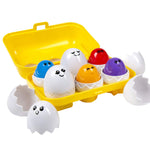Colorful toy eggs with faces in a yellow egg carton on a white background