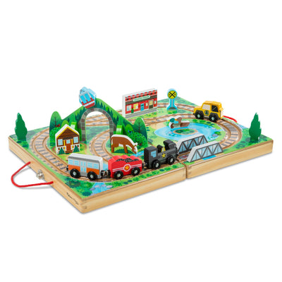 Toy train set with tracks, trains, and small buildings on a wooden base.