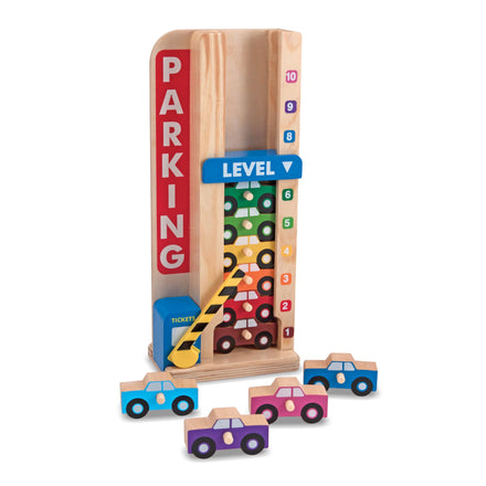Wooden toy parking garage with colorful cars on a white background