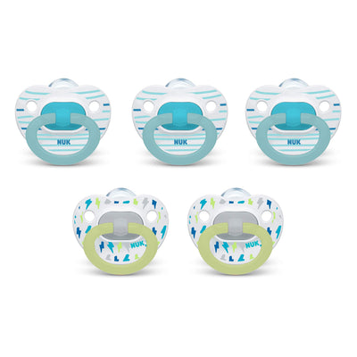Set of five NUK pacifiers with different designs on a white background