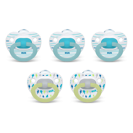 Set of five NUK pacifiers with different designs on a white background