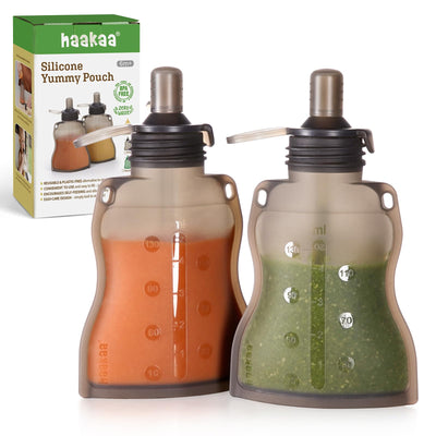 Two haakaa silicone yummy pouches with colorful liquids and packaging in the background.
