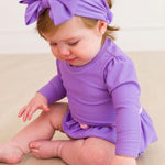 RuffleButts Baby Girls UPF50+ Princess Long Sleeve Bow Skirted One Piece Swimsuit - Amethyst Princess, 18-24m