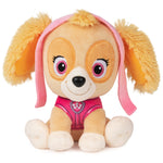 Plush toy dog with pink ears and outfit on a white background