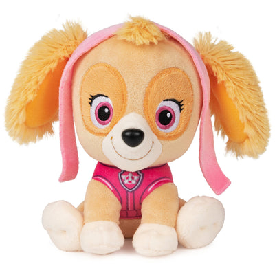 Plush toy dog with pink ears and outfit on a white background