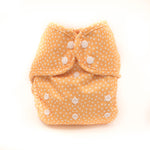 Yellow diaper with white polka dots on a white background