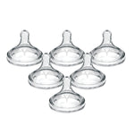 Set of five clear baby bottle nipples on a white background