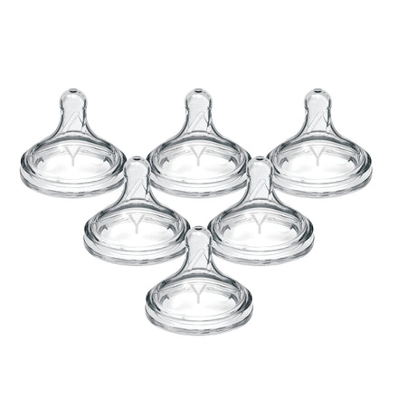 Set of five clear baby bottle nipples on a white background