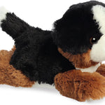 Plush toy dog with black, brown, and white fur on a white background