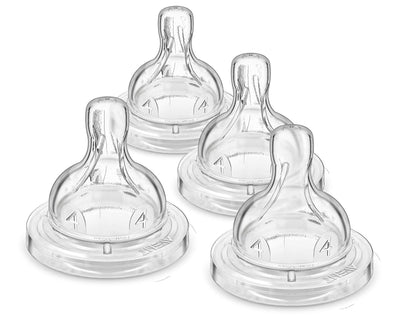 Set of four clear baby bottle nipples on a white background