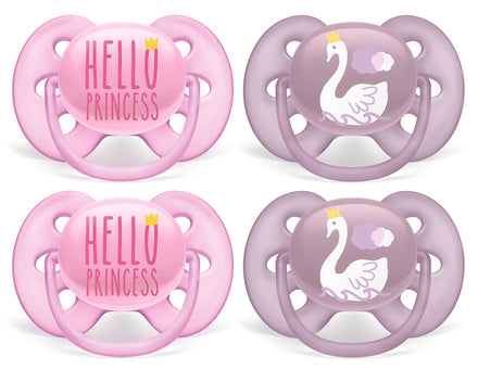 Two pink 'Hello Princess' pacifiers and two purple swan pacifiers on a white background