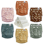 Set of patterned cloth diapers and rolled-up towels on a white background