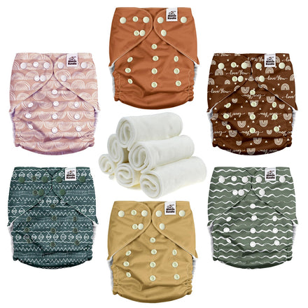 Set of patterned cloth diapers and rolled-up towels on a white background