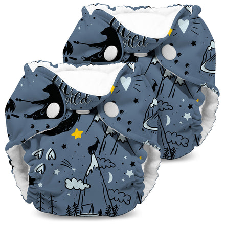 Two baby diapers with a night-themed design featuring stars, moons, and trees on a white background.