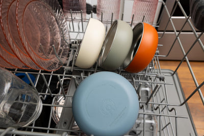 Dishwasher with a blue lid on a silver rack