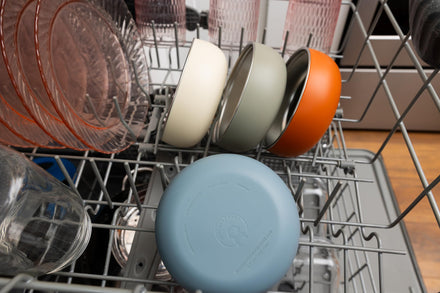 Dishwasher with a blue lid on a silver rack