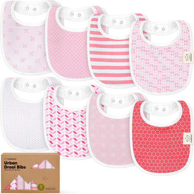 Set of eight baby bibs with various pink patterns on a white background, accompanied by a cardboard box labeled 'Urban Drool Bibs'.