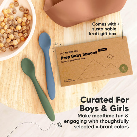 Two baby spoons on a wooden surface with a Kecababies packaging box.
