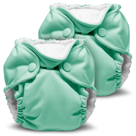Two mint green cloth diapers with white interiors on a white background